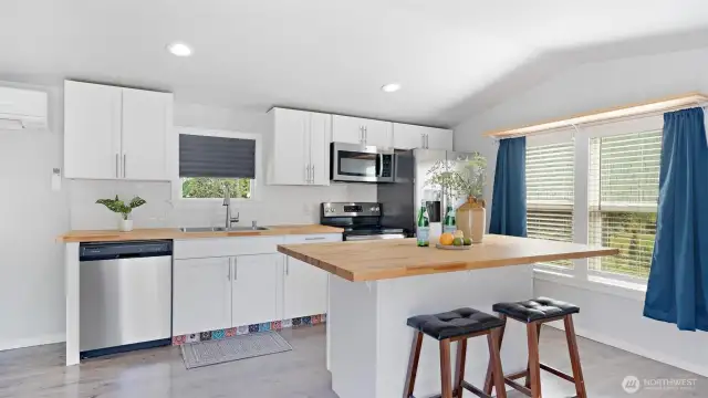 The heart of the home truly shines with a spacious island, breakfast bar seating for casual meals or conversation, and stainless steel appliances ready to handle everything from quick snacks to weekend feasts!