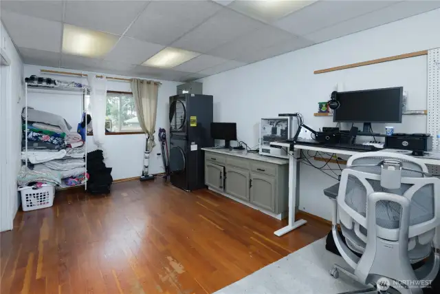 Spacious multipurpose room is being used as an office and laundry room.