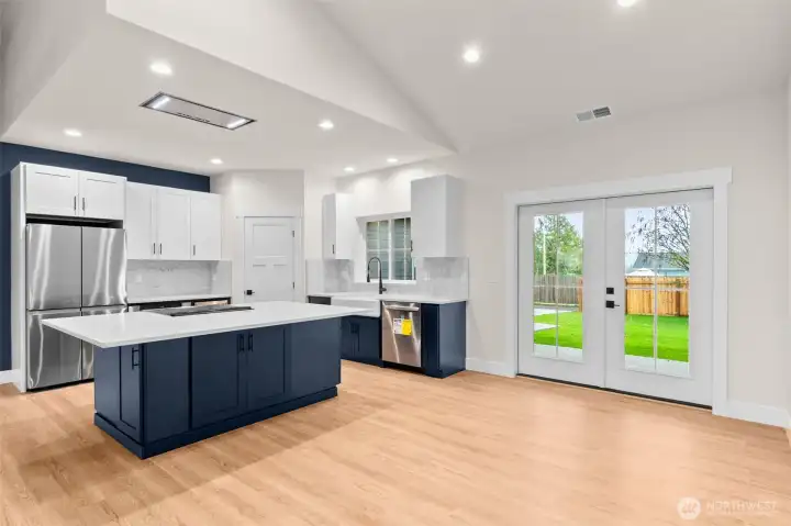 A beautifully designed kitchen featuring a Kohler farmhouse sink, flush-mount 36” split range hood, and a sleek microwave drawer for a streamlined look.