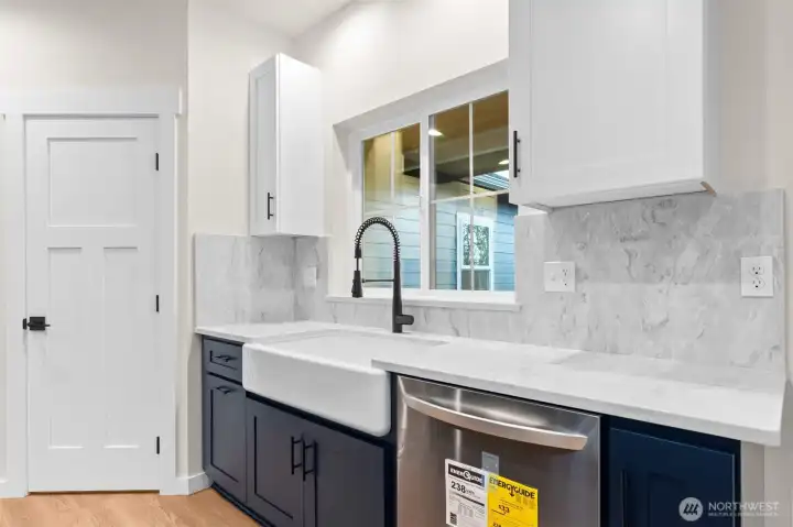 The large farmhouse sink with a view of the backyard. LG Wi-Fi enabled dishwasher.