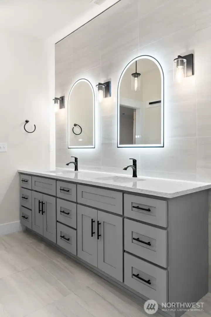 Modern bathrooms finished with sleek Kohler one-piece toilets and quiet Panasonic WhisperValue ventilation fans.