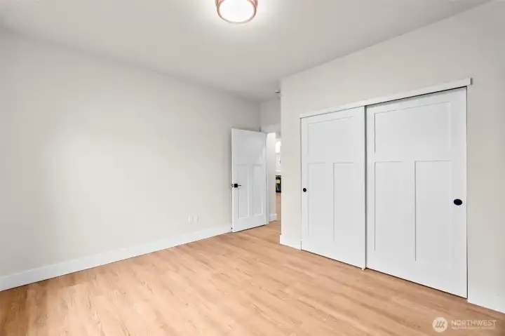 Another view of the second guest bedroom with ample closet space and large windows.