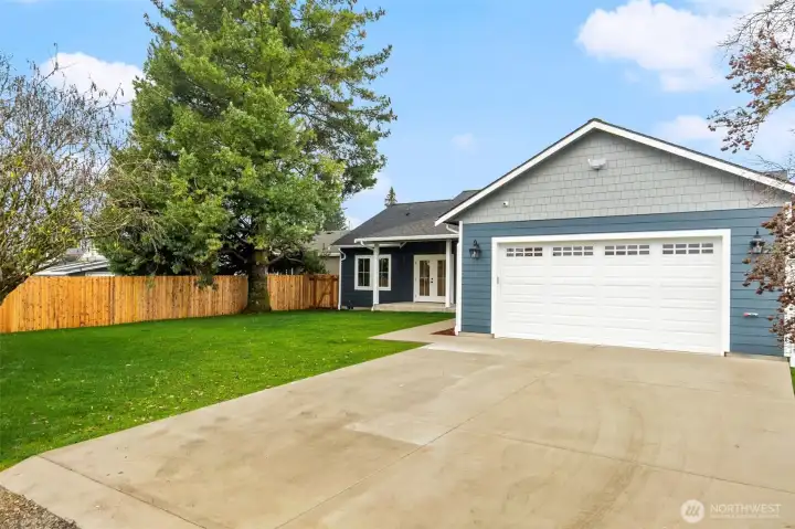 Freshly landscaped backyard and driveway with hot water access, offering both function and curb appeal as the landscaping comes to life this spring.