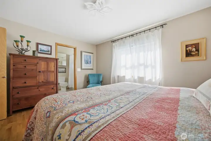 Looking across the spacious primary bedroom toward the full bath.