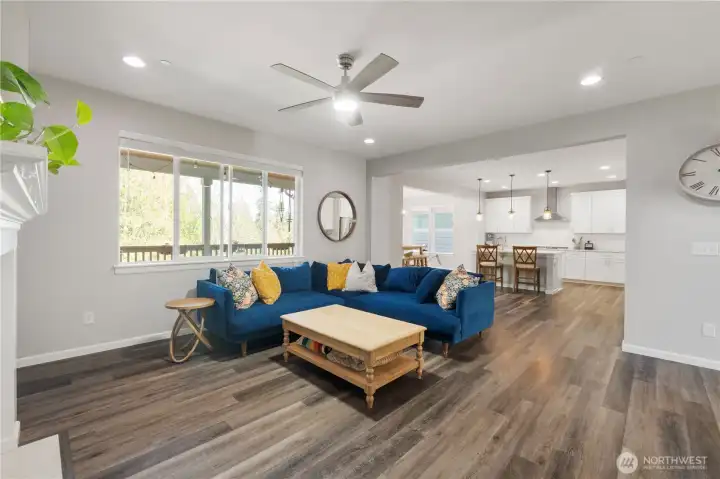 Considerably larger than this photo represents, this is the great room with open space to the very accommodating kitchen (much of it to the right of that wall that you see, with the clock on it). Note the open dining space in the background. Some people use that as an additional seating area, bottom line is… Very flexible space for you to utilize, design, and furnish the way you like! Or, change it up often, if you're "that type." TeeHee