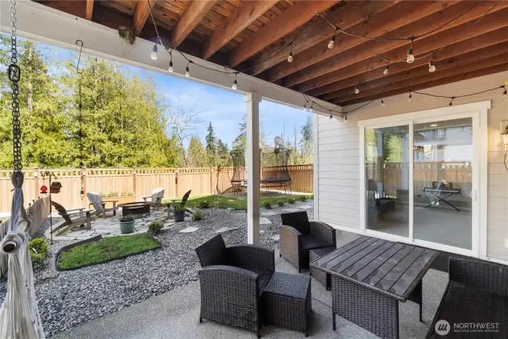 Ground-level patio is perfect for those lazy daze...check out the hammock hooks, night-lighting and plenty of outdoor furniture space. This patio is covered and those sliders to the right are into the downstairs bonus / media / workout room.