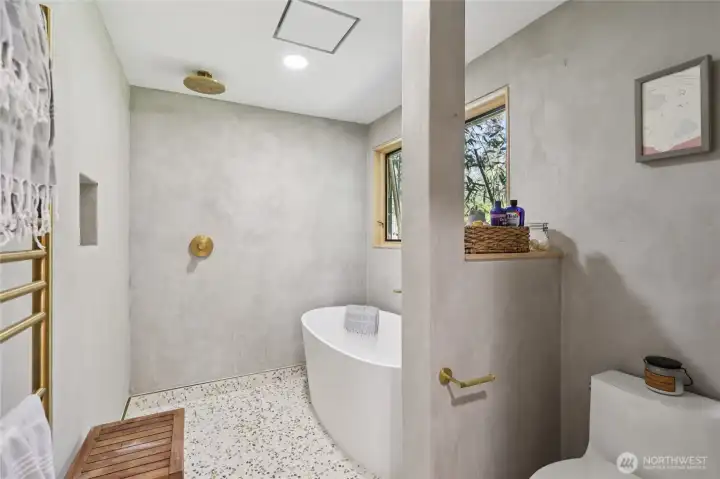 Euro style primary wet-bath includes custom vanity, Tadelakt plaster, volcanic limestone soaking tub & solid brass fixtures