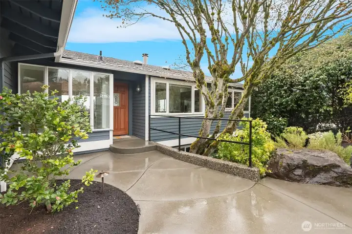 Verdant yard with mature plants greet you.