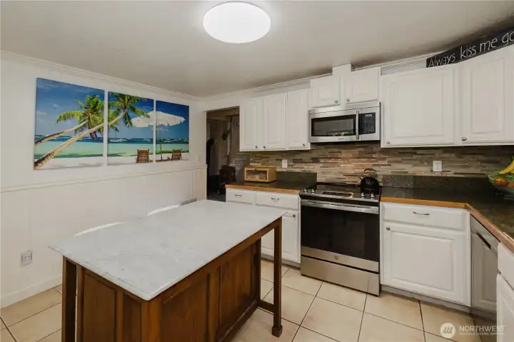 Modern Kitchen, Stainless steel appliances, all stay.  Moveable warm wood island also stays. Easy to maintain surfaces throughout. Natural stone backsplash