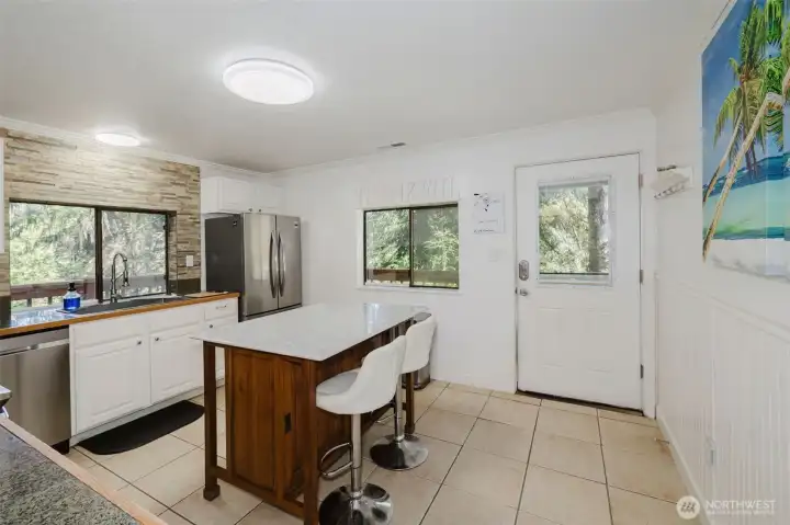 Practical, modern kitchen with Island and seating.  Door to back deck and side parking, convenient for groceries, entertaining and pets.