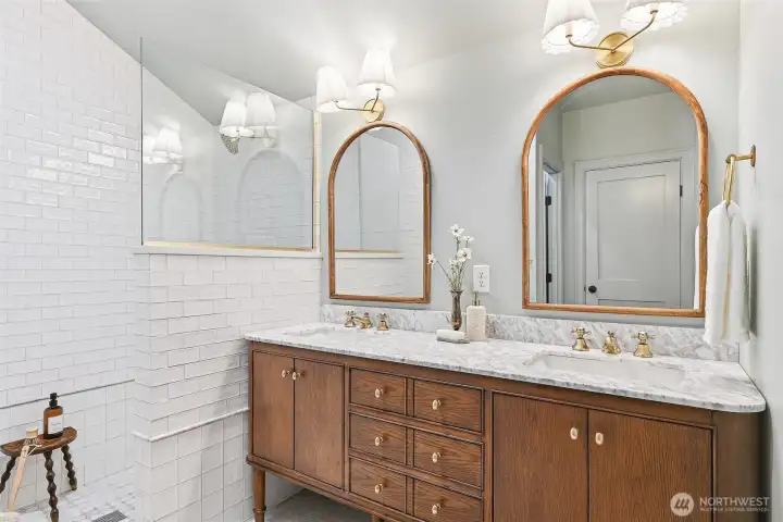 Stylishly appointed 3/4 bath on the main level with dual vanity and a subway tile shower.