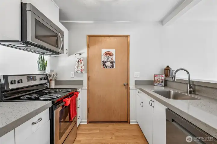 The kitchen features quartz countertops, white cabinetry and stainless steel appliances. The kitchen features quartz countertops, white cabinetry and stainless steel appliances.