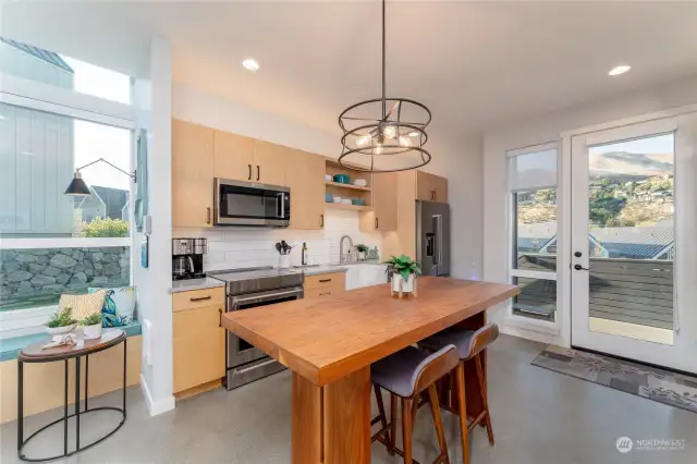 view 2 of kitchen w/ custom dining room table and high end appliances.