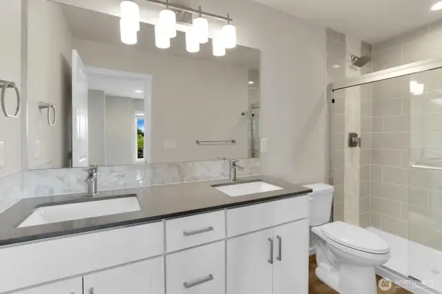 Primary bath for homesite 2. Beautiful backsplash and tiled shower.