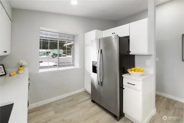 Inside view of kitchen with garden window facing porch and cul-de-sac.  New cabinet above refrigerator.