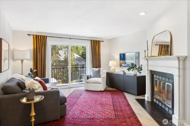Living room with slider  to front balcony and wood burning fireplace