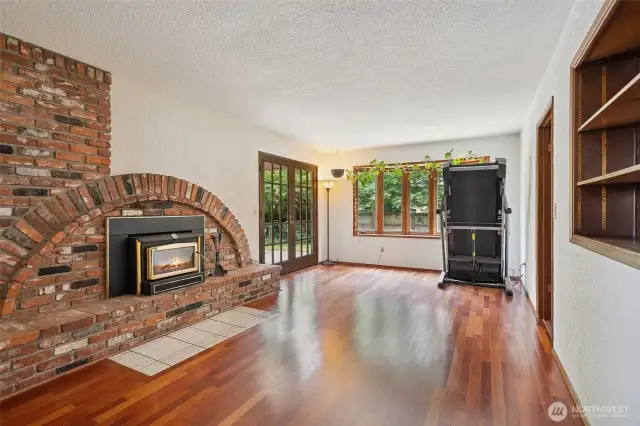 Family room just off entry with kitchen on the left and door to the backyard on the right. Unique brick fireplace design and Brazilian Cherry hardwood floors here too