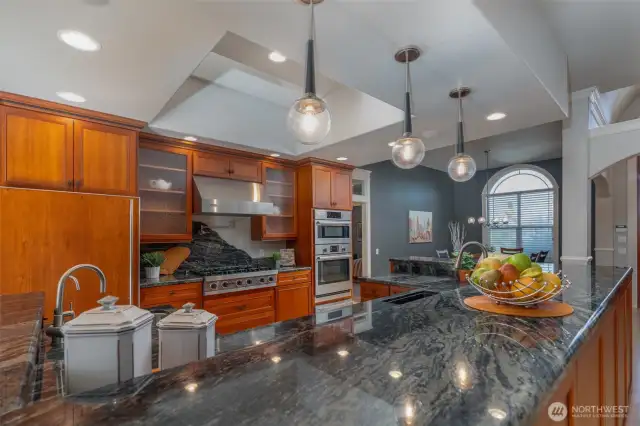 Extraordinary chef’s kitchen featuring Viking & Bosch appliances, expansive granite island, pendant lighting, and rich custom cabinetry—designed for both function and entertaining.