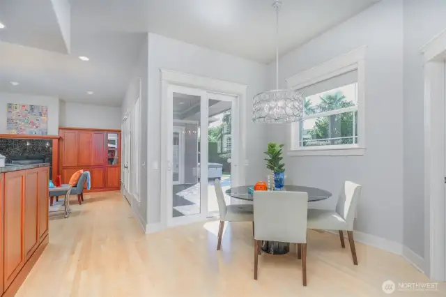 Sunlit breakfast nook with modern chandelier and sliding doors that open to the covered patio and private backyard oasis—perfect for morning coffee or casual dining.