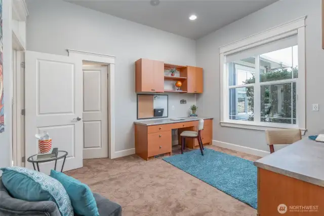 Versatile bedroom currently styled as a home office, featuring dual built-in desks, large window for natural light, and flexible space to suit work or guest needs.