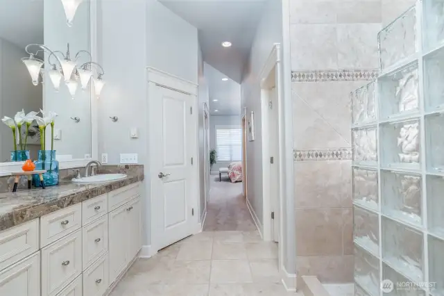Another view of the expansive primary bath, showcasing its spacious layout, glass-block shower, and elegant finishes—designed to feel both open and luxurious.