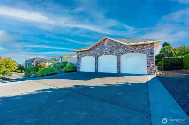 Impressive curb appeal with exposed aggregate concrete driveway, classic brick accents, and a fully finished 3-car garage offering ample parking and storage.