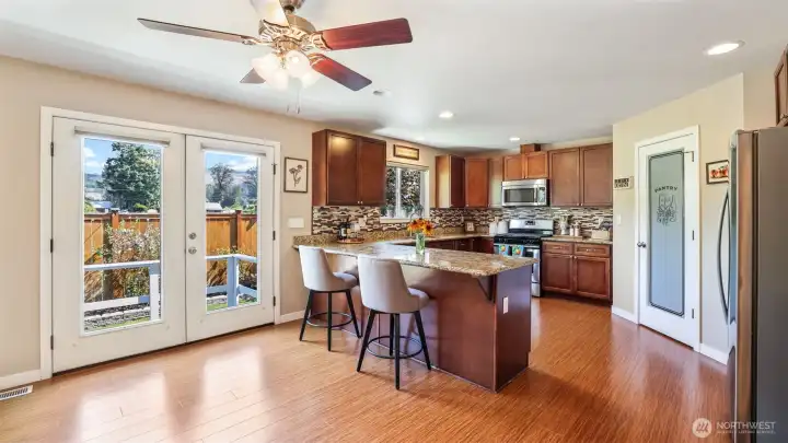 Kitchen includes full tile backsplash, granite counters, breakfast bar, walk-in pantry, gas range, and all appliances are included.