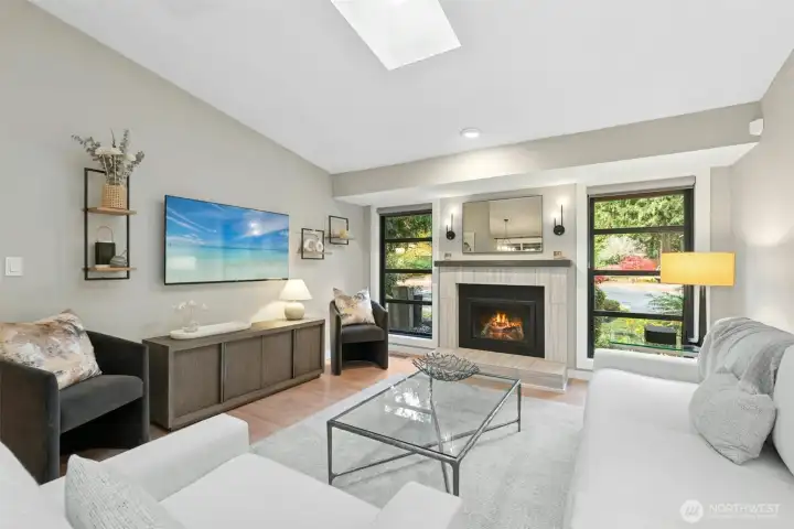 Light-filled living room with vaulted ceilings, skylight and a cozy gas fireplace