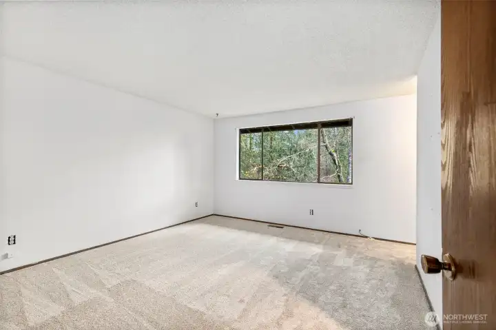Primary Suite window overlooks a private treed setting & back yard