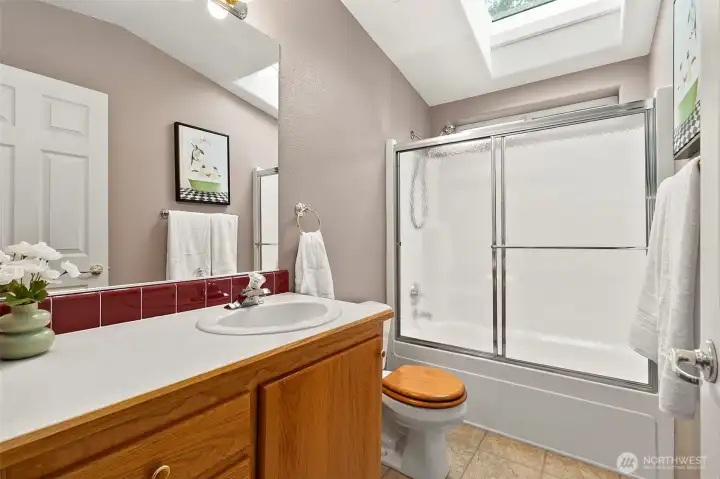 Hallway full bathroom with a skylight