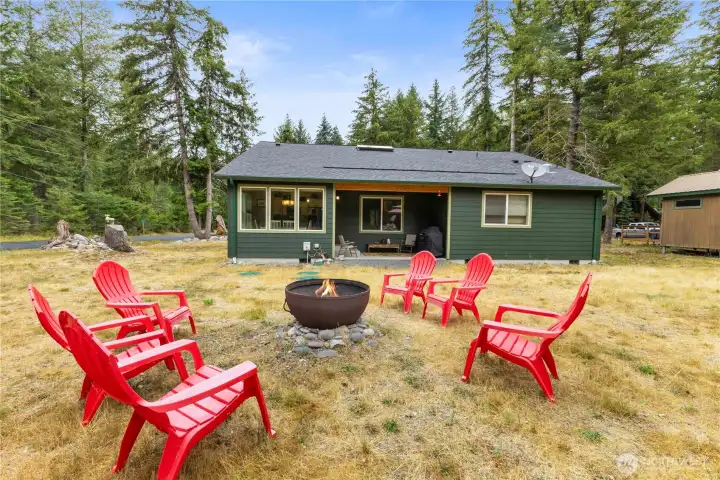 Level back yard is great for entertaining friends around a campfire. (Metal fire ring liner does not convey).