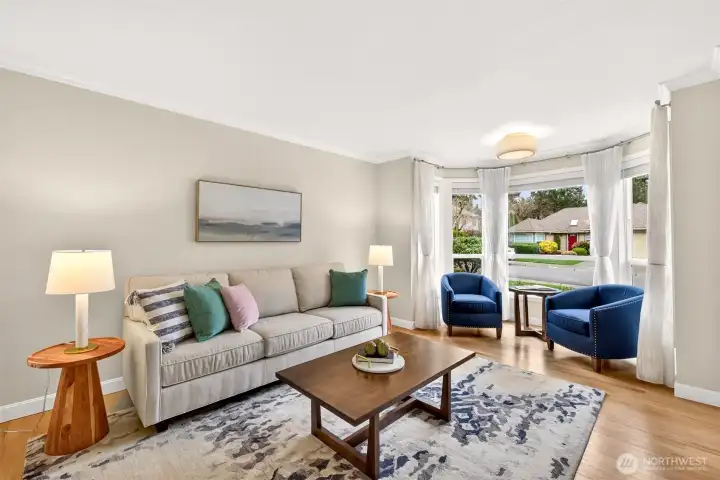 The bay window creates an airy focal point and a comfortable everyday living zone, with custom window treatments that balance privacy and light.