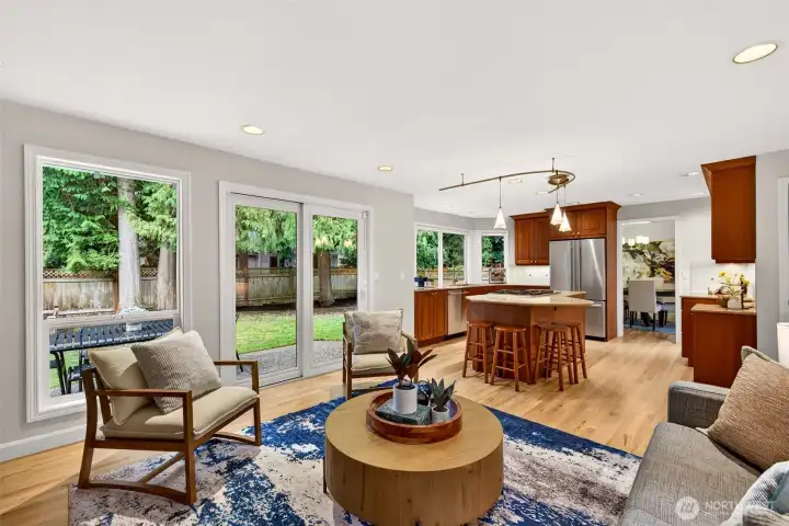 Large windows and sliding door access make it easy to step outside and enjoy the private, evergreen bordered yard, while the open connection to the kitchen keeps entertaining seamless.