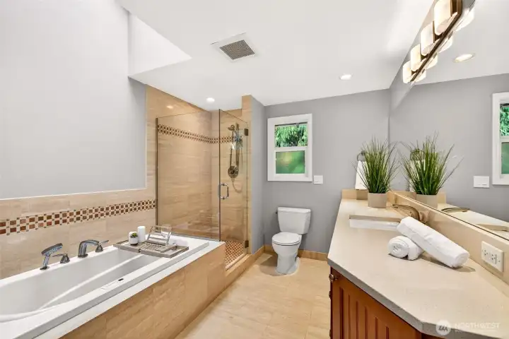 The primary bath feels spa inspired with a BainUltra heated air-jet hydrotherapy tub, a glass enclosed shower with timeless tilework, and a long vanity that makes mornings smoother.