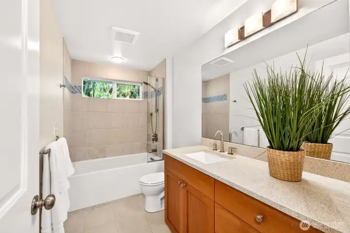 The full hall bath features a clean, durable fiberglass tub, an extended vanity for everyday storage, and bright lighting for a fresh, functional feel.