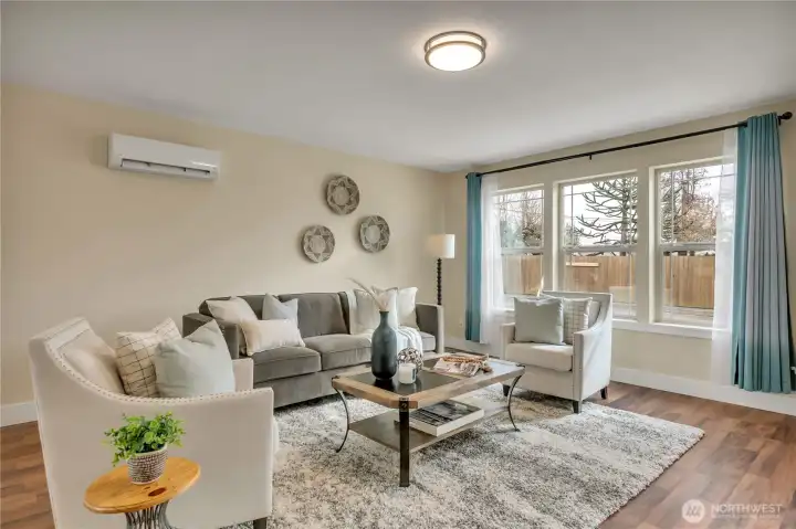 Spacious living room area with nearly floor-to-ceiling windows!  Vinyl-plank hardwood flooring that withstands daily living.