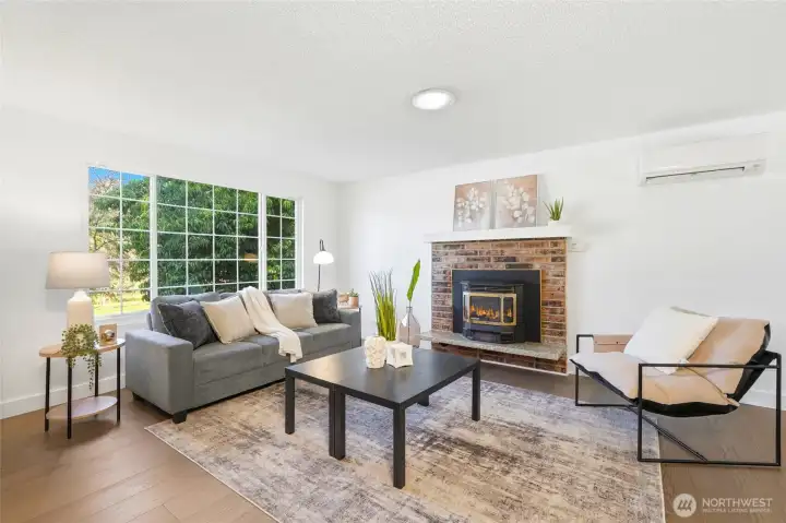 Gorgeous living room with cozy fireplace overlooks large front yard.