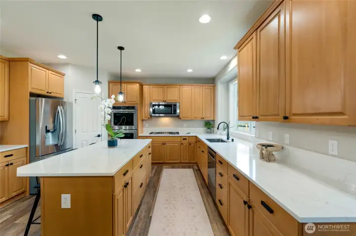 The kitchen has been remodeled with new quartz countertops, stainless steel appliances, and floors.