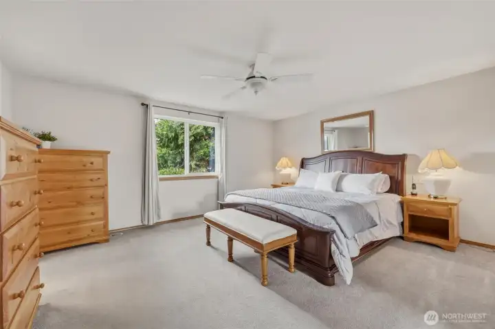 Primary bedroom is spacious, with ceiling fan for added sleeping comfort.