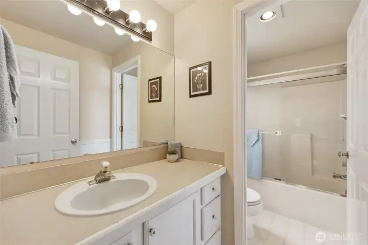 Hall bath is situated adjacent to these bedrooms, and smartly designed with two space for easy sharing. Shower/tub combo and commode have window for natural light and extra ventilation.