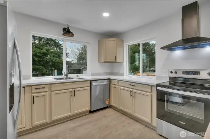 This kitchen features three large windows that provide an abundance of natural light
