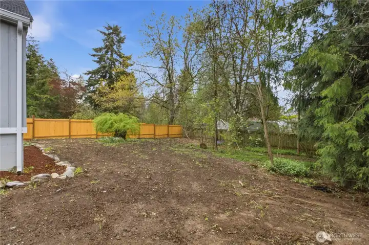 This private backyard is partially fenced and offers a blank canvas for your creative landscaping ideas, or you can choose to keep it in its natural, serene state