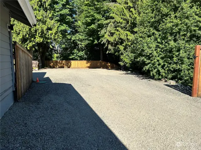 Gravel driveway to RV parking. Gate closes for fully fenced backyard.