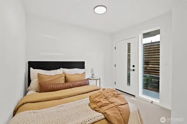 Lower level bedroom with access to back patio. Model home. Colors and finishes may vary.