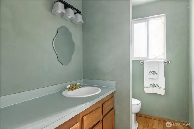 Downstairs half bath is  next to the kitchen and across from the laundry area.