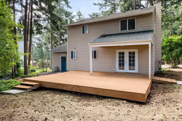 Back Deck with steps leading towards spacious outbuilding.