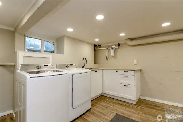 You have a laundry sink, custom cabinets wiht a lazy susan for full storage, a whole house water filtration system and washer and dryer stay!