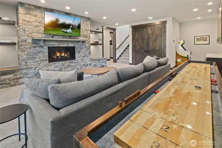 Rec room stone fireplace adds cozy ambiance.