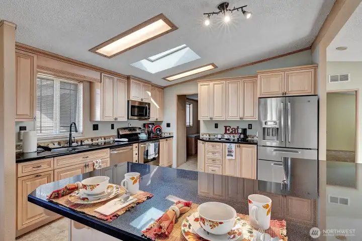 Chefs delight, updated, modern kitchen. Large island with storage below. Cabinets have pullouts for your convenience. Mixer cabinet with pullup and power for all your baking needs. Built in wine rack. Open ledge storage areas. Ample prep and storage space in this spectacular kitchen. Coffee bar or butler station too! All appliances are newer stainless steel. This kitchen is HUGE! Room for more than one Cook to be working at one time.