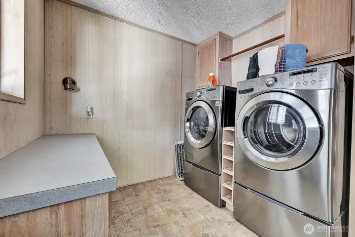 Utility room off the kitchen area has workstation for folding laundry etc. State of the art energy efficient washer and dryer for your convenience. Cabinets and storage space for all your laundry necessities. Energy efficient furnance also in this room. Access door to covered carport and back yard area.